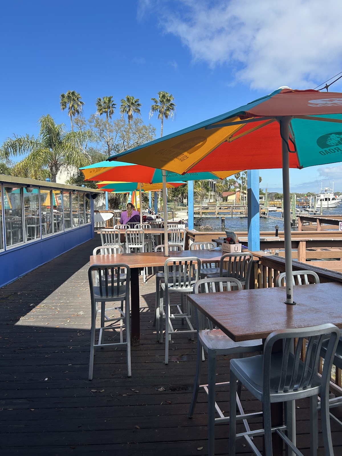 Colourful umbrellas over Whiskey River's outdoor tables beside the Cotee River