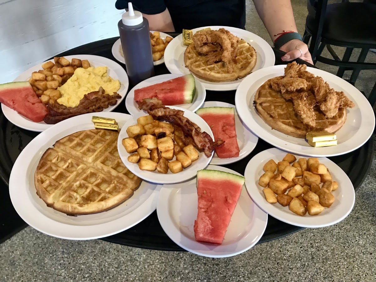 Breakfast plates with waffles, eggs and bacon at Whiskey River